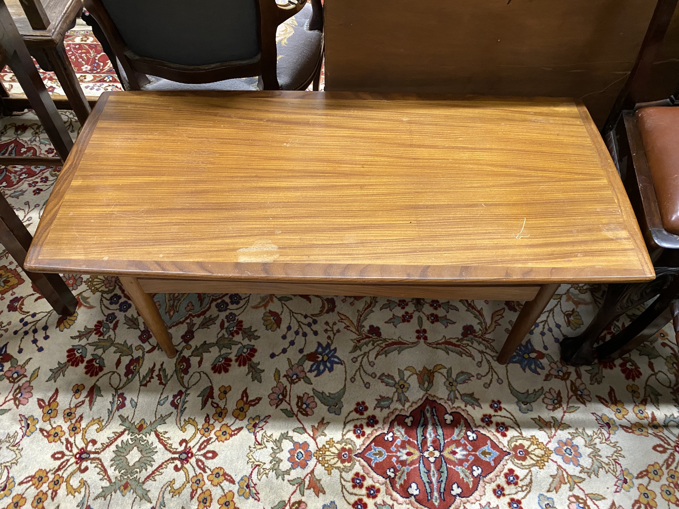 A mid century rectangular teak coffee table, length 118cm, depth 65cm, height 44cm together with a mid century teak magazine rack